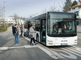 Menschen steigen in einen Bus ein