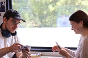 Zwei junge Menschen spielen Karten im Zug