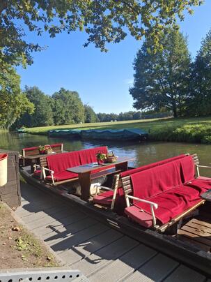 Bild eines Spreewald-Kahns mit roten Decken im Sonnenschein
