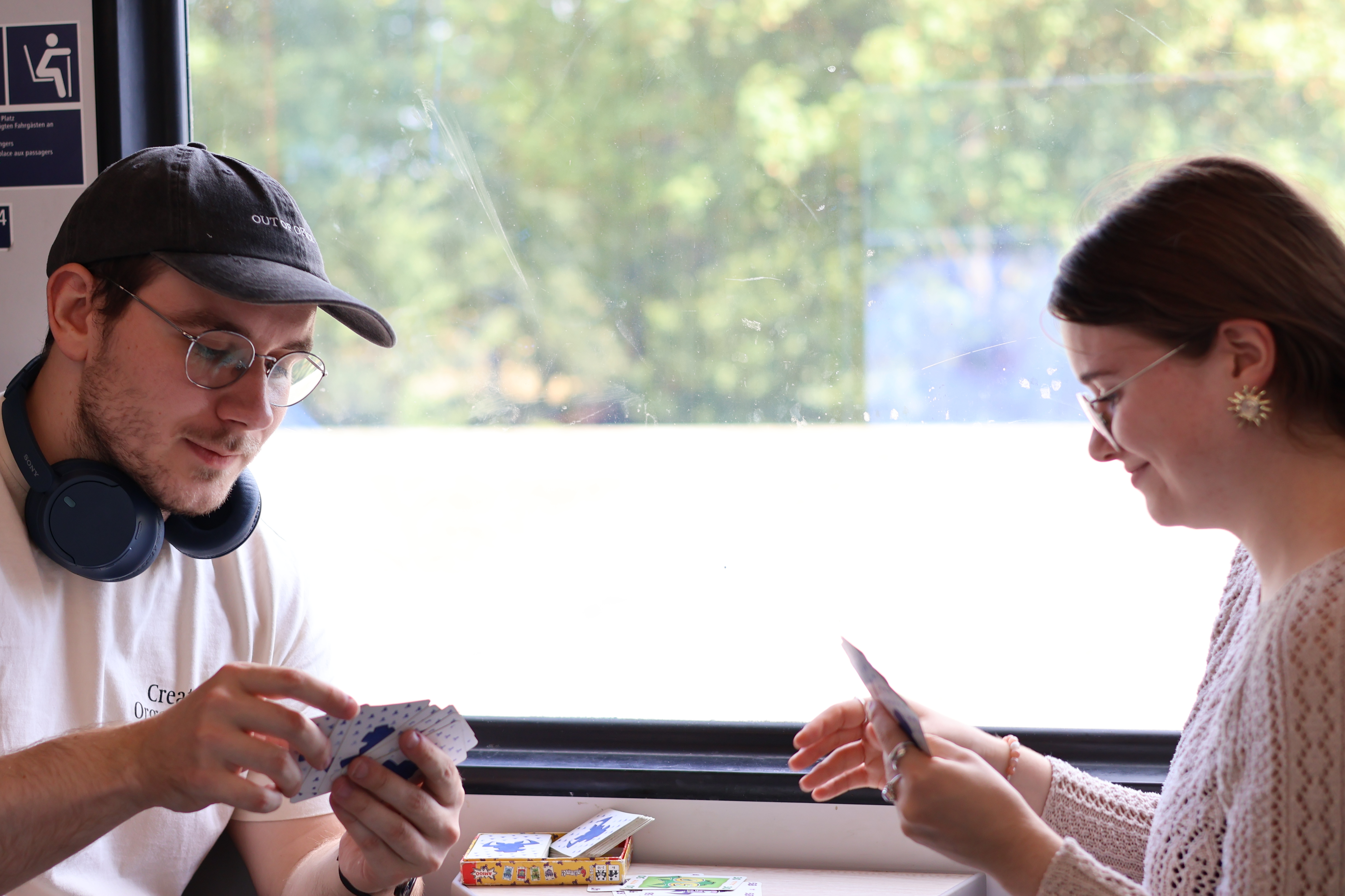 Zwei junge Menschen spielen Karten im Zug